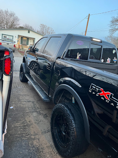 A black truck parked next to a white truck