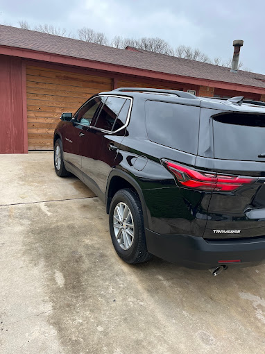 A black suv parked in front of a garage